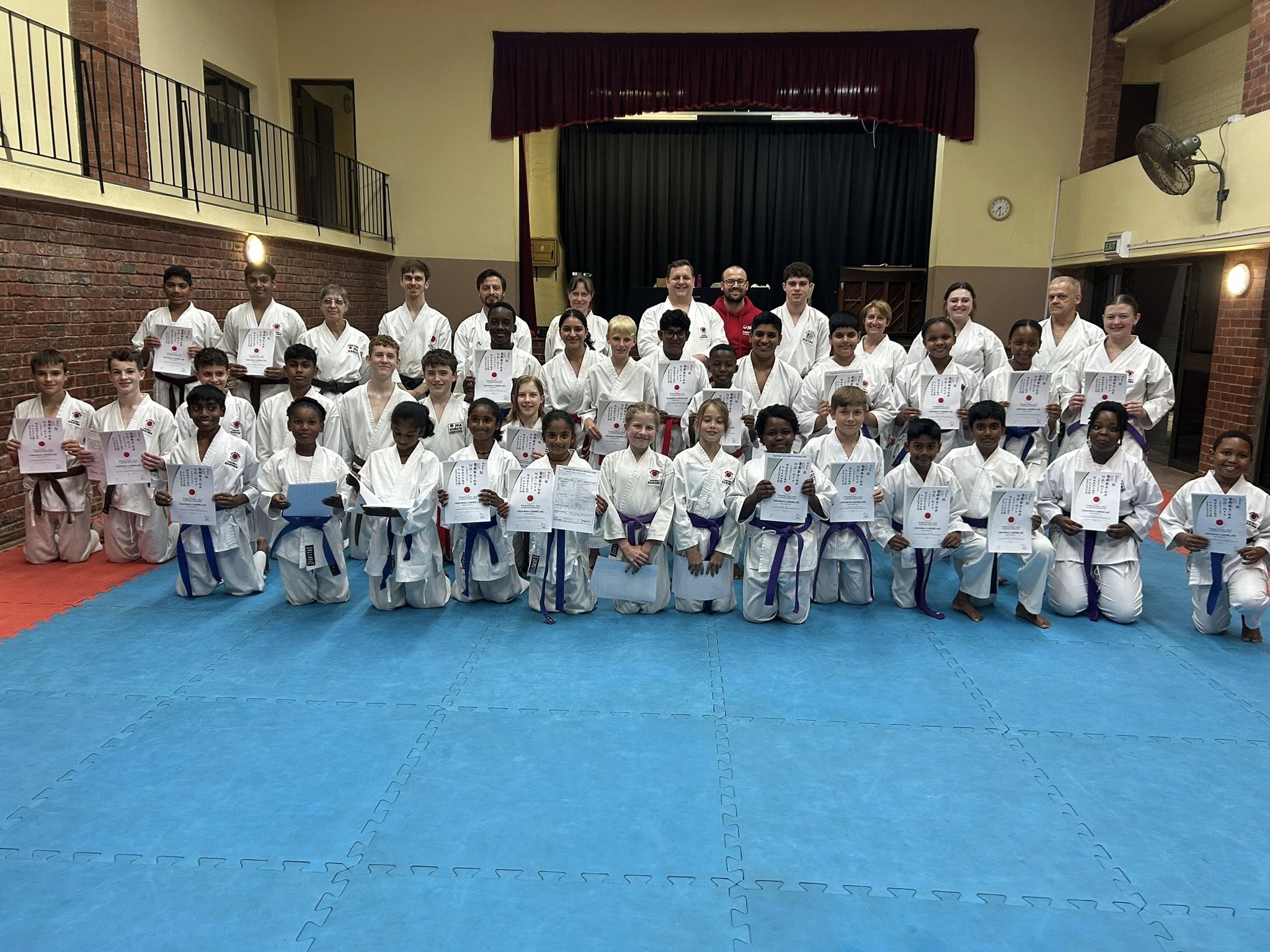 Large group of students with grading certificates in the dojo, June 2025